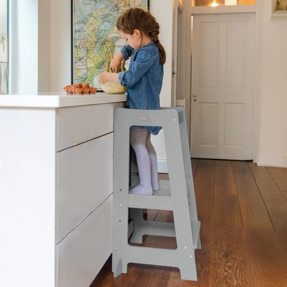 girl on grey toddler tower cooking mixing eggs
